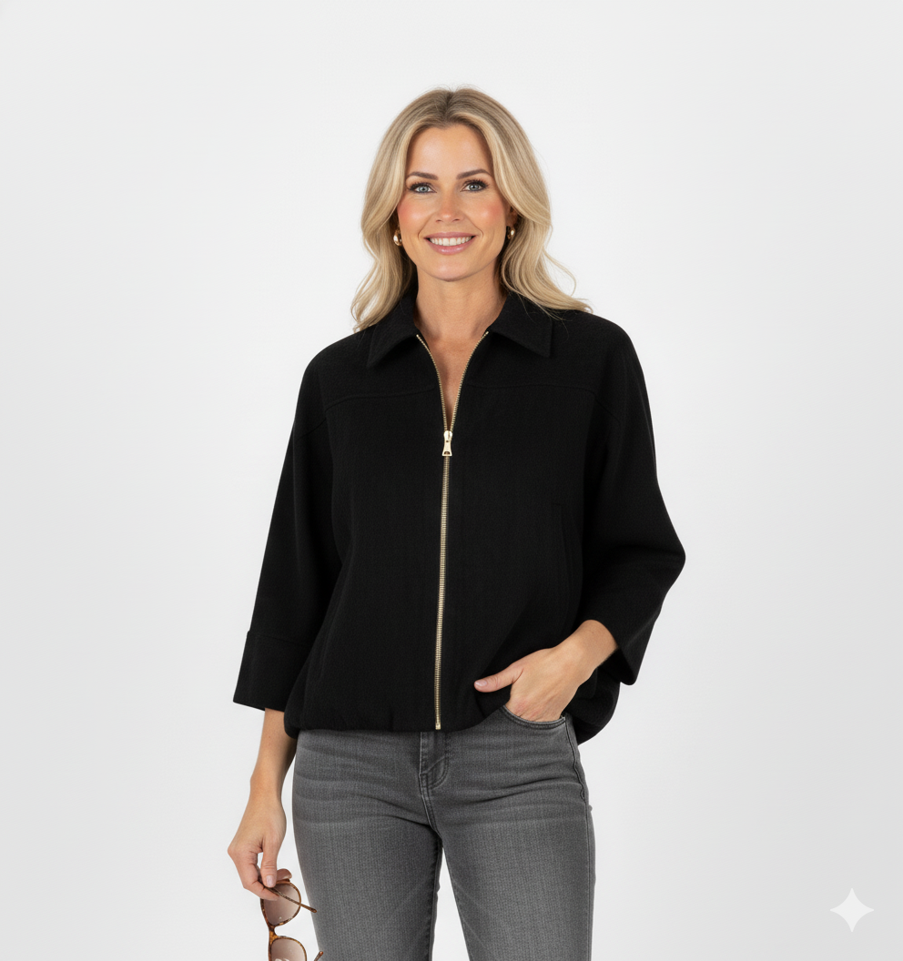 Vrouw met zwarte korte jas met kraag en gouden ritssluiting – luxe damesjack met moderne, elegante uitstraling.