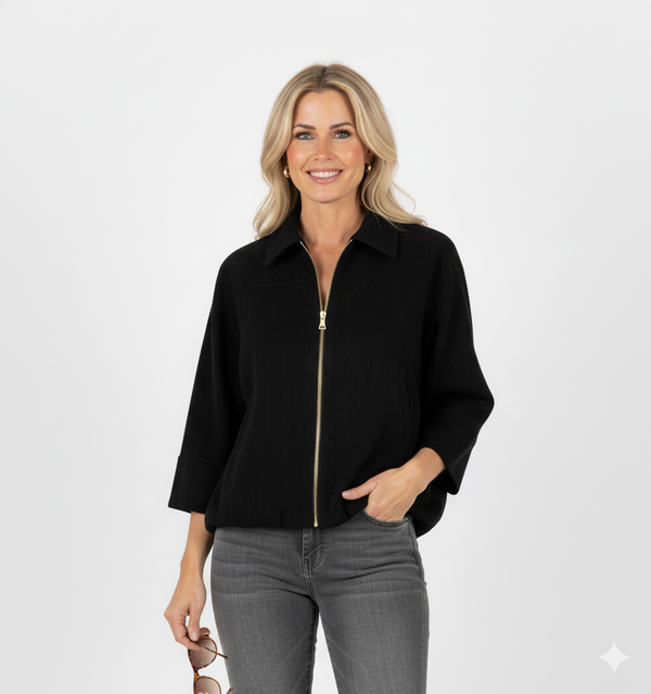 Vrouw met zwarte korte jas met kraag en gouden ritssluiting – luxe damesjack met moderne, elegante uitstraling.