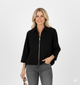 Vrouw met zwarte korte jas met kraag en gouden ritssluiting – luxe damesjack met moderne, elegante uitstraling.