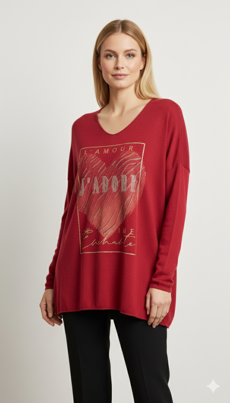 Vrouw met rode V-hals top met gouden “L’Amour J’Adore” hartprint, gecombineerd met zwarte broek – stijlvolle damesblouse met romantisch design.