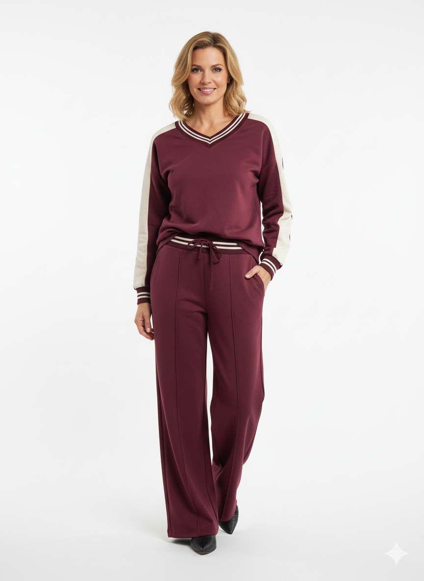 “Model draagt een bordeauxrode dames set met V-hals trui en broek met witte details.”

“Sportieve dames set in bordeauxrood met contraststrepen en rechte broek.”

“Trendy bordeauxrode outfit – V-hals trui met sportieve accenten en broek.”

“Bordeauxrode dames set met sportieve uitstraling – ideaal voor casual en athleisure looks.”

“Comfortabele bordeauxrode dames set met V-hals trui en elastische broek.”
