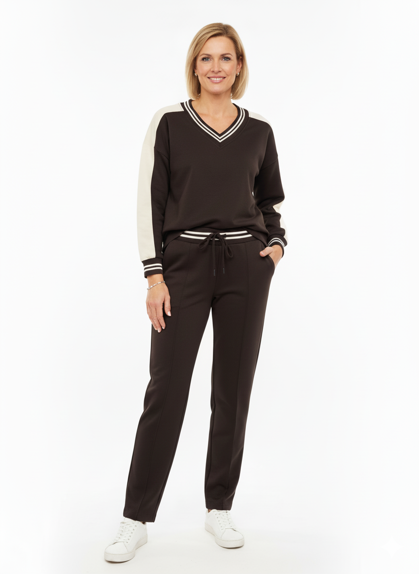 Model draagt een zwarte dames set met V-hals trui en broek.”

“Sportieve dames set in zwart met witte details en bijpassende broek.”

“Stijlvolle zwarte outfit voor dames – V-hals trui met contrasterende details en broek.”

“Comfortabele dames set in zwart – perfect voor casual en athleisure looks.”

“Trendy zwarte dames set met sportieve V-hals trui en elastische broek.”