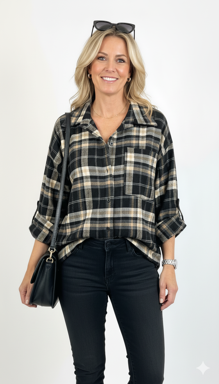 Model draagt zwart-beige ruit blouse met opgerolde mouwen – casual damesblouse met zachte stof.