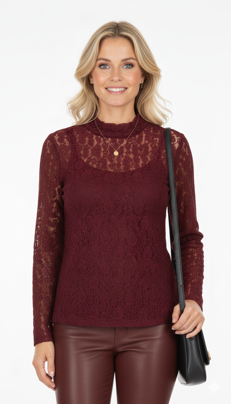 Vrouw draagt bordeauxrode kanten top met lange mouwen en opstaande hals – elegante en vrouwelijke blouse.