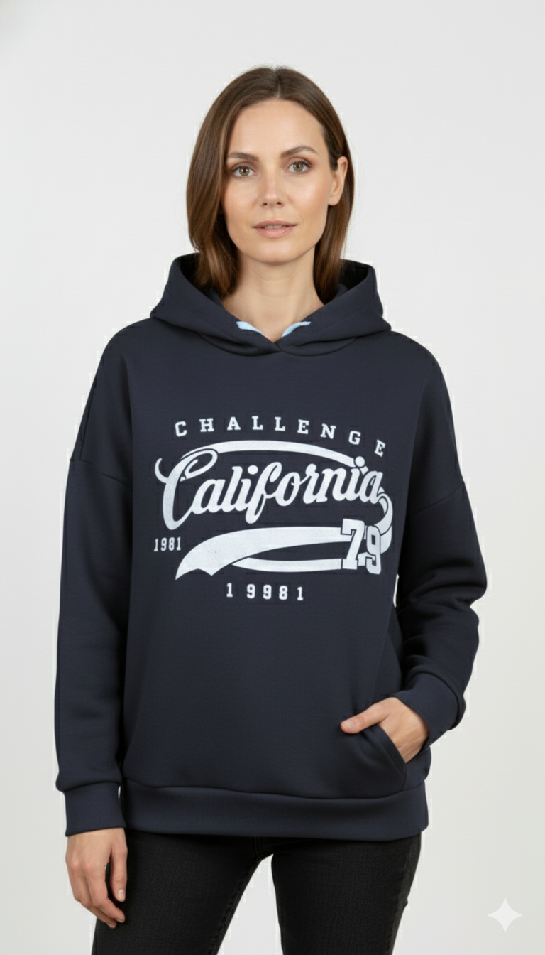 Vrouw met donkerblauwe hoodie met ‘California Challenge 1981’ print en capuchon – sportieve damestrui met witte vintage opdruk.