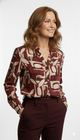 Model draagt bordeaux abstract print blouse met knoopsluiting – elegante lange mouw dames blouse.