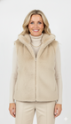 Model draagt beige luxe faux fur bodywarmer – zachte damesbodywarmer met opstaande kraag.