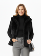 Model draagt zwarte luxe faux fur bodywarmer – zachte damesbodywarmer met opstaande kraag.