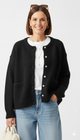 Model draagt zwart gebreid vest met knopen en zakjes – zacht fluffy damesvest.